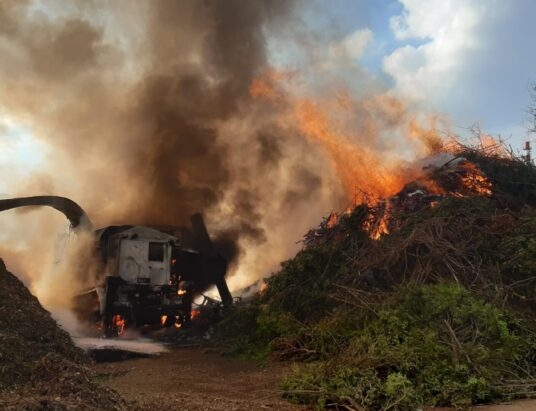Ciężarówka z rębakiem i odpady zielone w ogniu